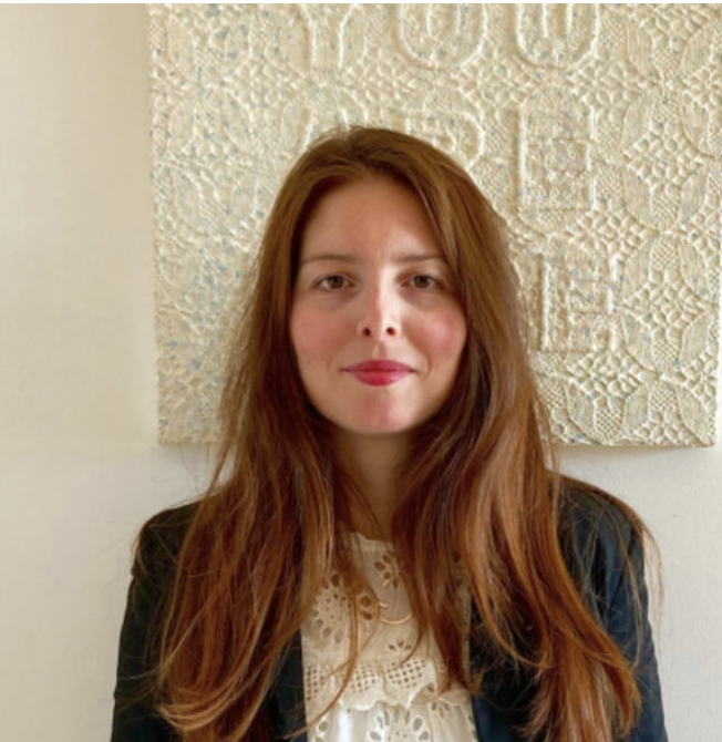 Woman with red hair, brown eyes, a paiting of Sam Havdtoy on the background.